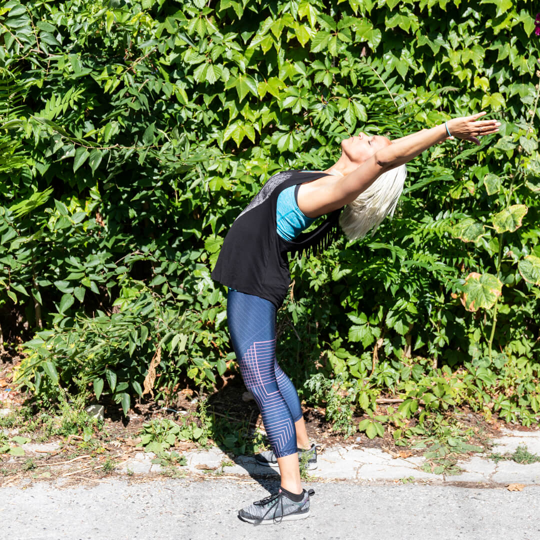 stretching in front of some greenery